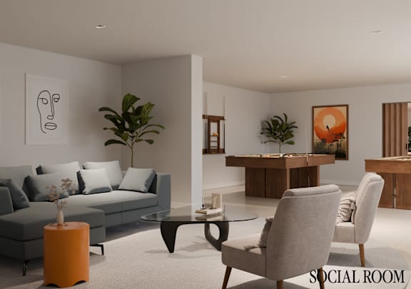A modern living room with a grey sofa, a grey armchair, a coffee table, and a painting on the wall.