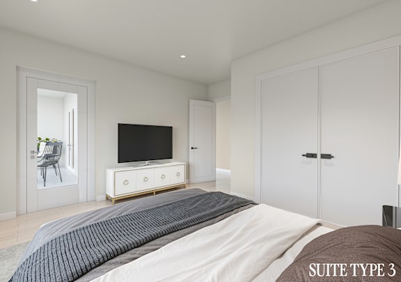A bedroom with a bed, a television, and a chair in the corner.