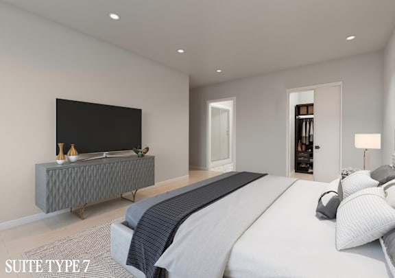 A modern bedroom with a large bed and a flat screen TV.