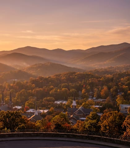 A beautiful sunset over a mountainous landscape with a town nestled in the valley.