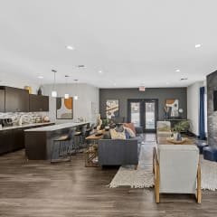 a living room with a fireplace and a kitchen in the background