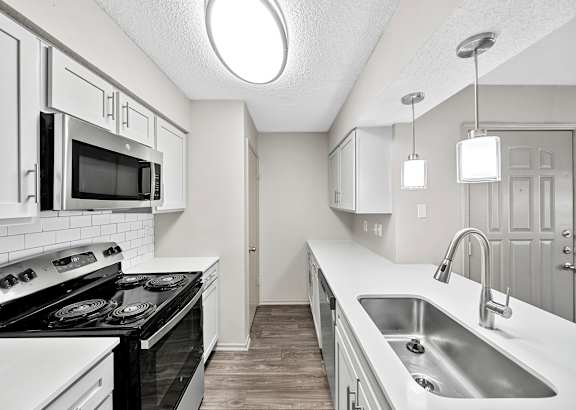 A kitchen with black and white appliances and cabinets.