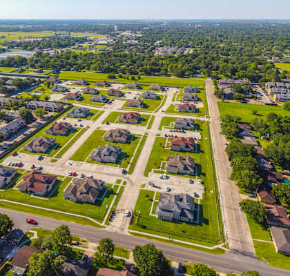 A suburban neighborhood with large townhomes and gated entrance.