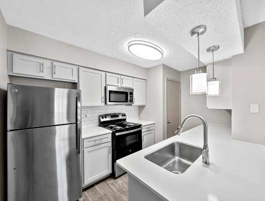 a kitchen with white cabinets and stainless steel appliances