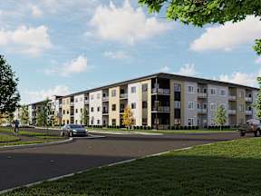 A modern apartment complex with cars parked in front.