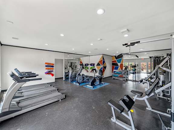 A gym with treadmills, weights, and exercise equipment.