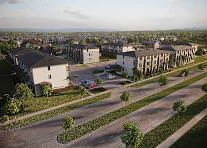 A large building complex with a parking lot in front.