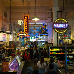 a crowd of people walking through a busy market