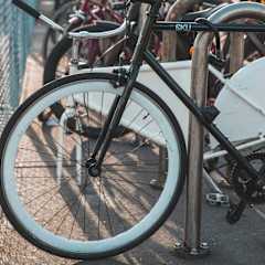 a row of bikes parked next to a fence
