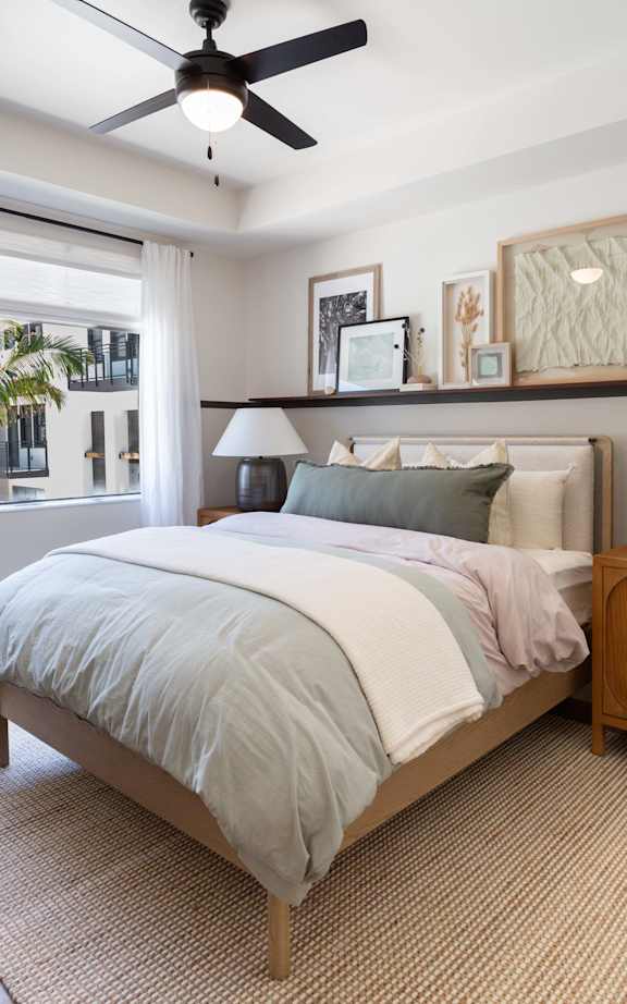 A bedroom with a large bed and a ceiling fan.