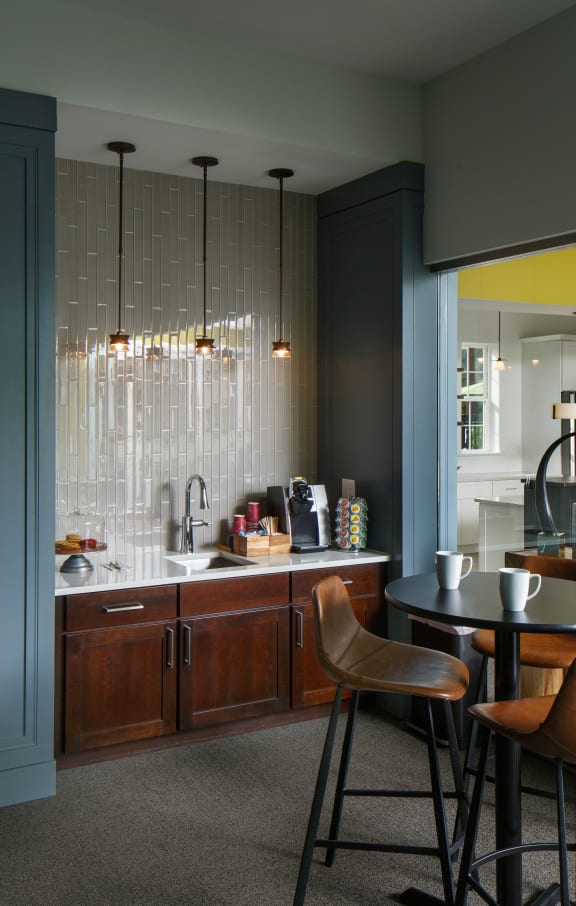 a kitchen with a counter and chairs and a sink