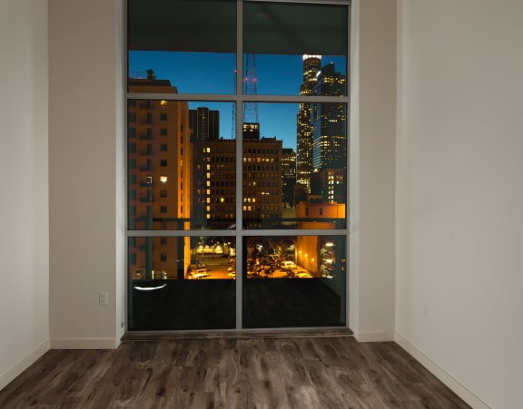 unfurnished bedroom with wood style flooring and floor to window ceiling at Topaz Apartments, Los Angeles, 90013