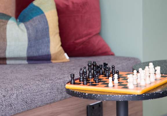 a living room with a couch and a table with chess on it