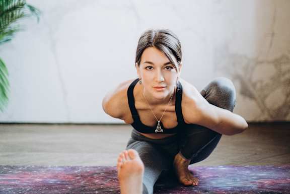 a woman doing a yoga pose on a yoga mat