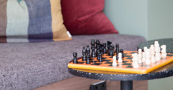 a living room with a couch and a table with chess on it