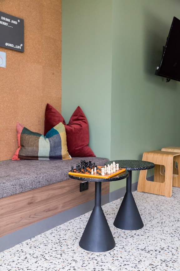 a game of chess on a table in a room with a couch and pillows