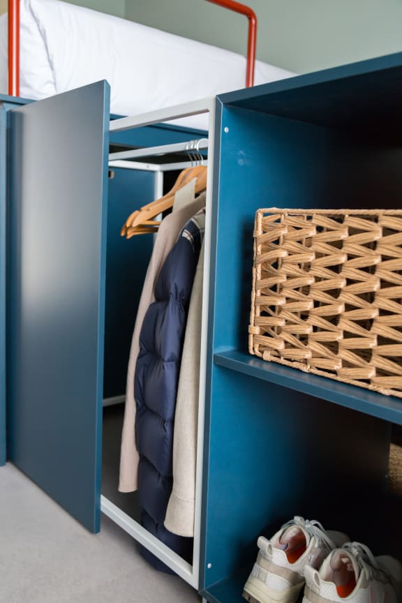 a closet with two blue cabinets and a pair of shoes on the floor