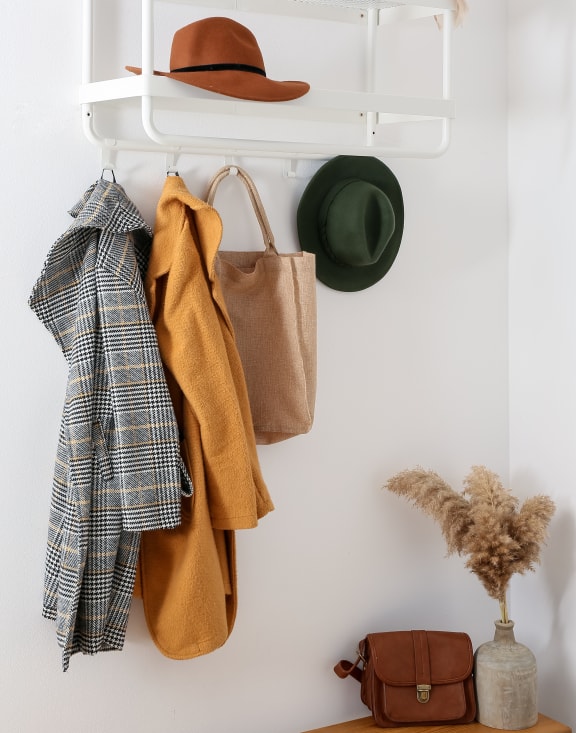 a white shelf with clothes and a hat hanging on it at Delta Pointe Apartments, Sacramento