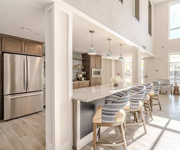 A modern kitchen with a long island and chairs. at Sandpiper Glen 62+ Apartments, Orlando, FL