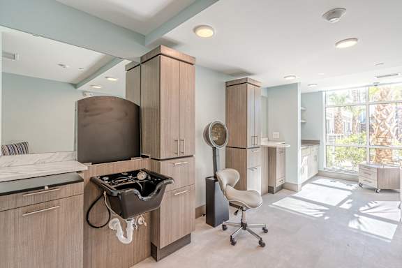 three women are looking at their hair in a salon at Sandpiper Glen 62+ Apartments, Orlando, FL, 32825