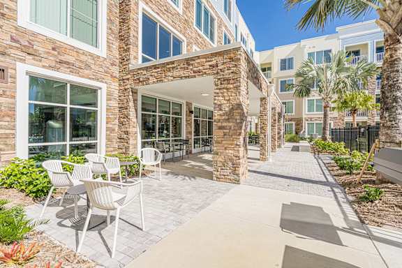 a woman sitting on a bench with a dog at Sandpiper Glen 62+ Apartments, Orlando, FL, 32825