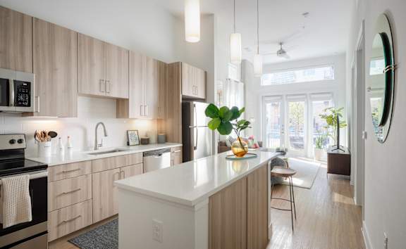 A modern kitchen with wooden cabinets and a white island.