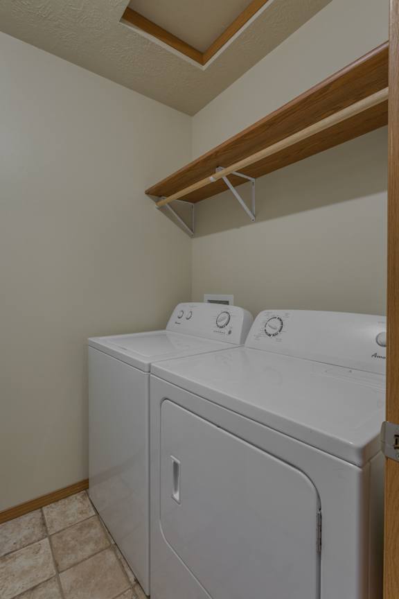 A white washing machine and dryer in a small laundry room.