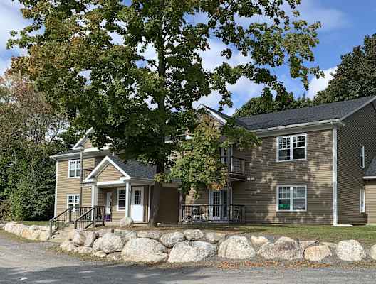 the front of a house with large rocks