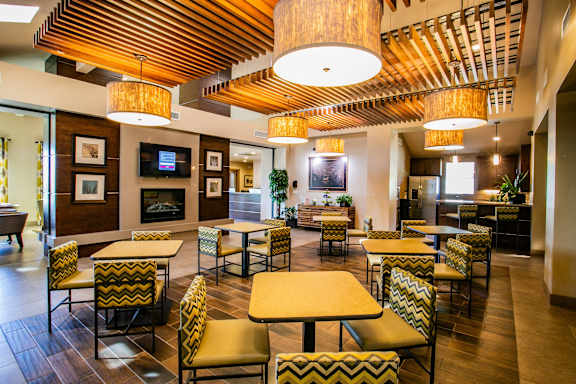 a living room with yellow chairs and a fireplace