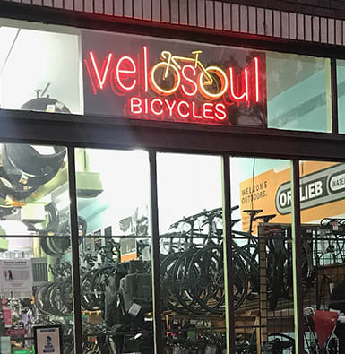 A neon bicycle sign in front of a local bike shop.