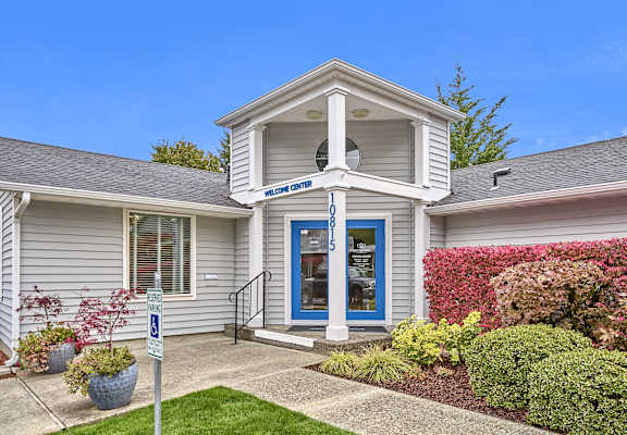 the front of a white house with a blue door