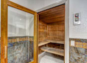 Thumbnail 21 of 54 - A wooden door with a glass window is open to a bathroom with a bench.