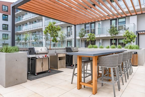 a communal patio with tables and chairs and barbecue grills