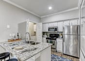 Thumbnail 2 of 54 - A kitchen with a granite countertop and stainless steel appliances.