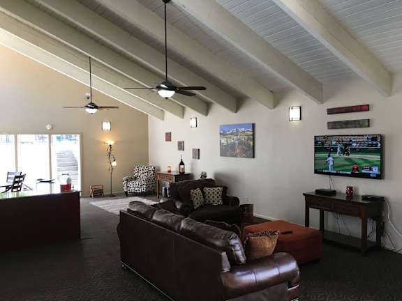 A seating area with a brown leather couch, a brown leather chair, and a television.
