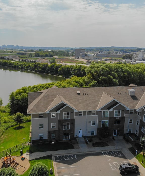 an aerial view of a building with a lake in the background