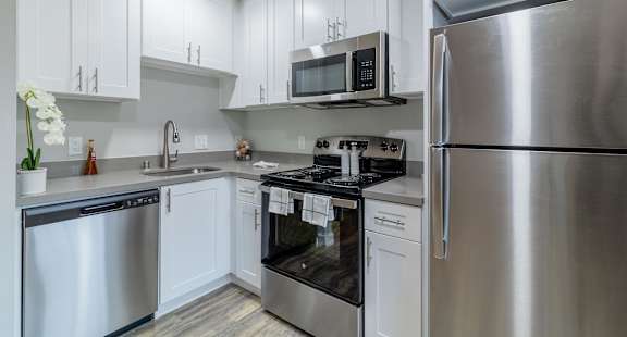 a kitchen with stainless steel appliances and white cabinets