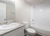 Thumbnail 5 of 34 - A white toilet sits next to a sink in a bathroom.