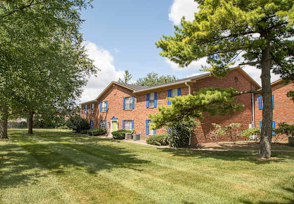 A red brick building with a green lawn in front.