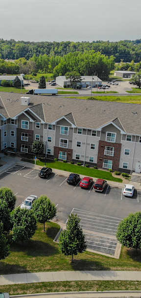 an aerial view of an apartment building in a parking lot
