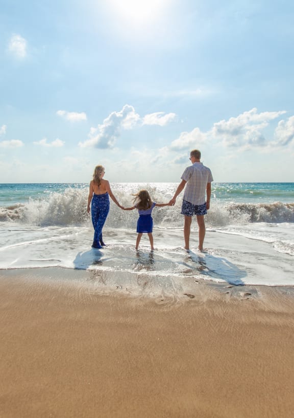 a family walking into the ocean on the beach