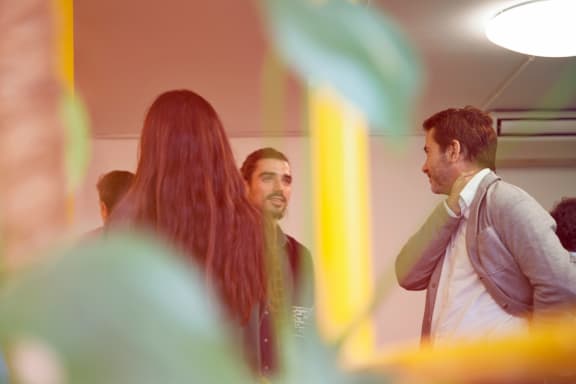 a group of people standing in a room talking
