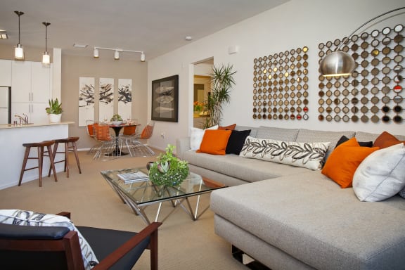 a living room with a gray couch and a glass table