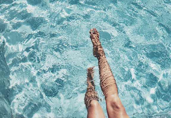 A person's legs sticking out of the water.