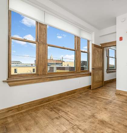 A room with wooden floors and a large window.