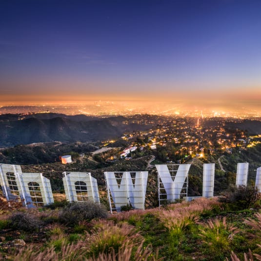 a photo of the hollywood sign at night with the city lights of los angeles in