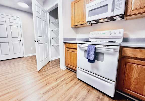 A white oven with a blue towel on it is in a kitchen.