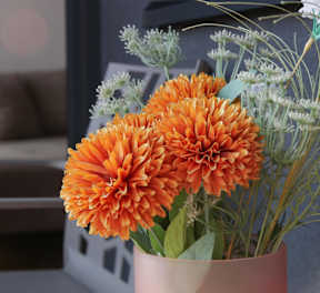a vase with orange flowers in a living room