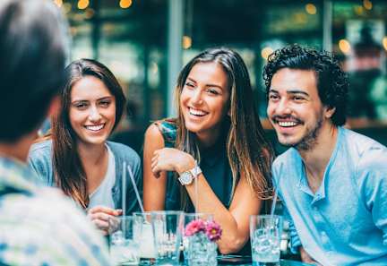 A group of people are sitting at a table, smiling and enjoying each other's company at Prairie Crossing, Texas 75244