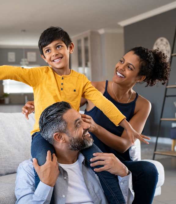 A family of three is having fun in their living room.